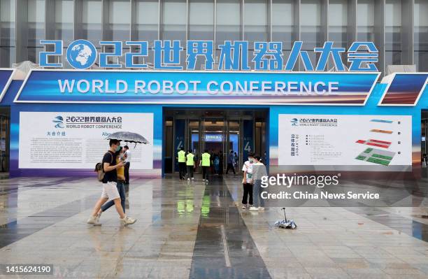 People walk by the entrance of Beijing Etrong International Exhibition & Convention Center during the 2022 World Robot Conference on August 18, 2022...