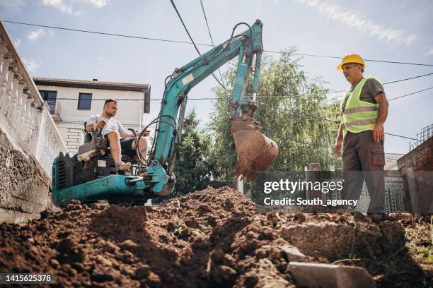 engineer coordinating work on construction site - grävmaskin bildbanksfoton och bilder