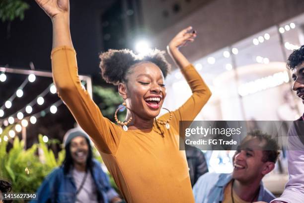 young woman dancing in the street with friends at night - dancing funny carefree woman stock pictures, royalty-free photos & images