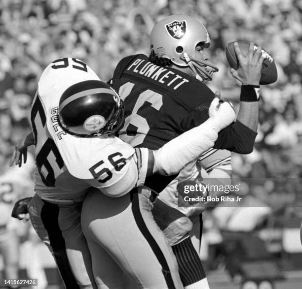 Los Angeles Raiders QB Jim Plunkett is tackled by Pittsburgh Steelers Robin Cole during game action against Pittsburgh Steelers in playoff game,...