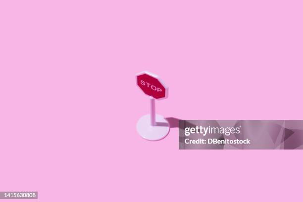 toy white plastic stop traffic sign on pink background. concept of driving, car, transport, prohibition, stop, highway code and end. - code pink stock pictures, royalty-free photos & images