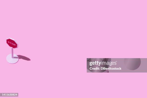 toy white plastic stop traffic sign, on the left side, on pink background. concept of driving, car, transport, prohibition, stop, highway code and end. - stop sign stock-fotos und bilder