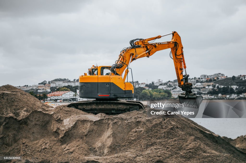 Excavation machine working at the seaside with sand