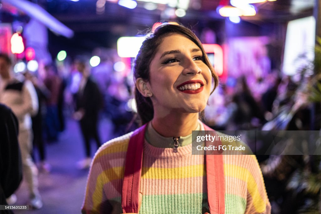 Mulher transgênero olhando ao redor na noite do festival de música