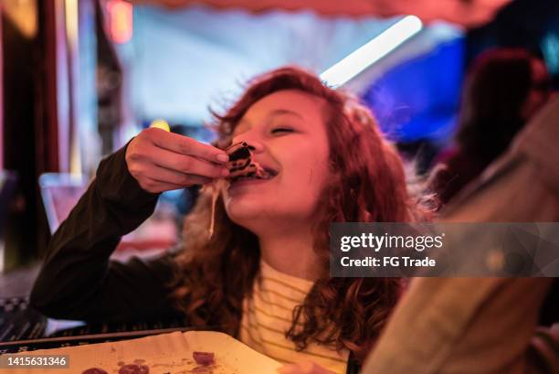 young woman eating pizza outdoors at night - cinema cafe 1 stock pictures, royalty-free photos & images