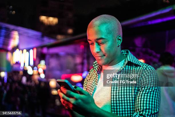 young man using the mobile phone at nightlife - music festival phone stock pictures, royalty-free photos & images