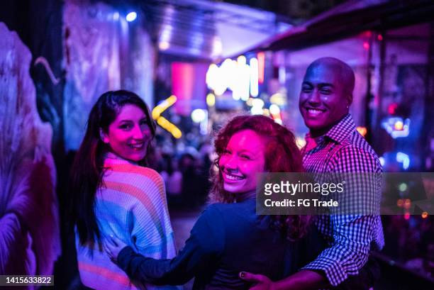 portrait of friends embracing at nightlife - including a transgender person - nightlife stock pictures, royalty-free photos & images