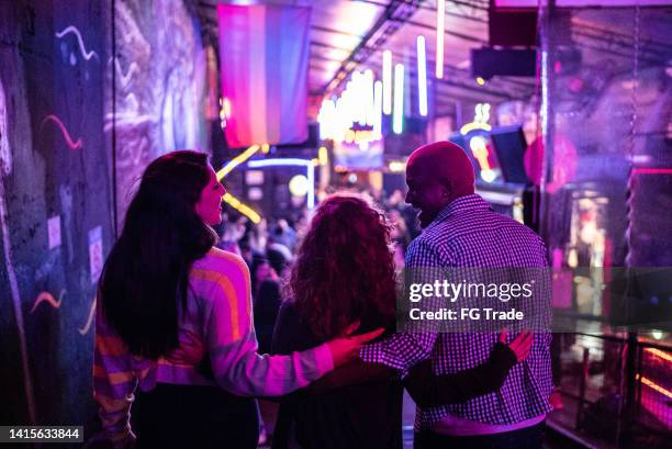 friends embracing at nightlife - including a transgender person - nachtleven stockfoto's en -beelden