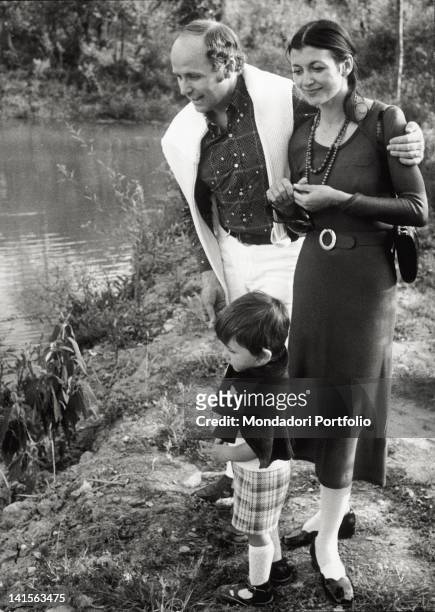 The Italian dancer Carla Fracci, her husband Beppe Menegatti and their son Francesco walk along a stream, in their farm. Tuscany, 1972.