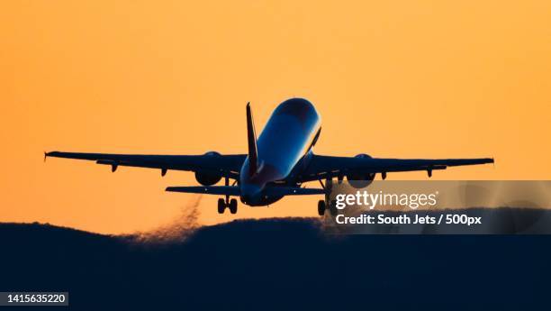 rear view silhouette of an airplane taking off at sunset - airplane take off stock pictures, royalty-free photos & images