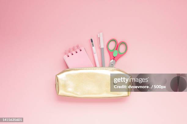 directly above shot of scissors and office supplies in purse on pink background - pencil case stock pictures, royalty-free photos & images