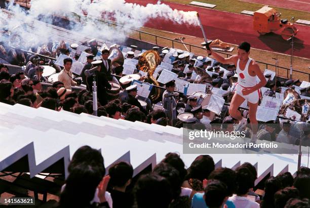 The Japanese Yoshinori Sakai, the last torch bearer of the opening ceremony, is climbing the stairs of the Olympic National Stadium to light the fire...