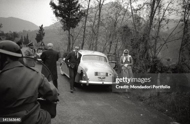 Prince Rainier Grimaldi of Monaco with his wife Grace Kelly are travelling to Rome. They have just got off their Rolls-Royce. The prince is now going...