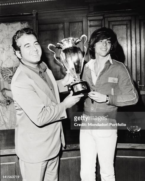 Festivalbar organizer Vittorio Salvetti presents the Trofeo Moccia to the winnen Claudio Baglioni. Asiago , summer 1974.