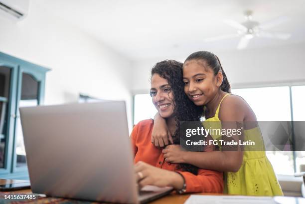 mother and daughter using laptop at home - family computer stock pictures, royalty-free photos & images