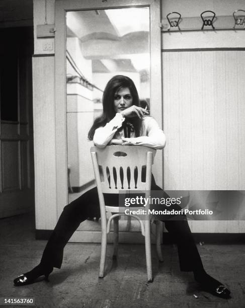 The Italian-French singer Dalida posing on a chair at the 17th edition of the Italian Song Festival where she has presented the song 'Ciao amore...