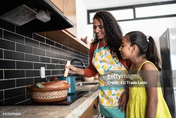 mother and daughter cooking at home - hot mexican girls stock pictures, royalty-free photos & images