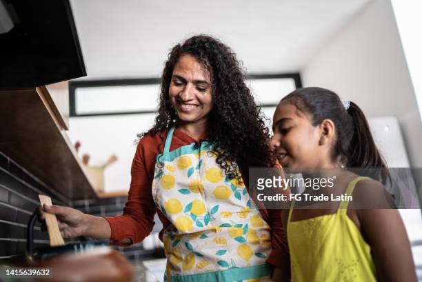 mother and daughter cooking at home - hot mexican girls stock pictures, royalty-free photos & images