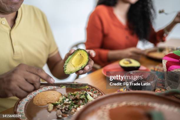 primo piano della famiglia messicana che pranza insieme nella sala da pranzo di casa - bbq avocado foto e immagini stock