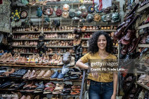 portrait of mid adult woman in front of her shoe store - shoe shop assistant stock pictures, royalty-free photos & images