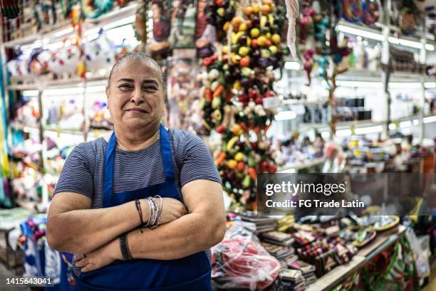 retrato de una mujer madura propietaria de una pequeña empresa frente a su tienda - mujeres mexicanas fotografías e imágenes de stock