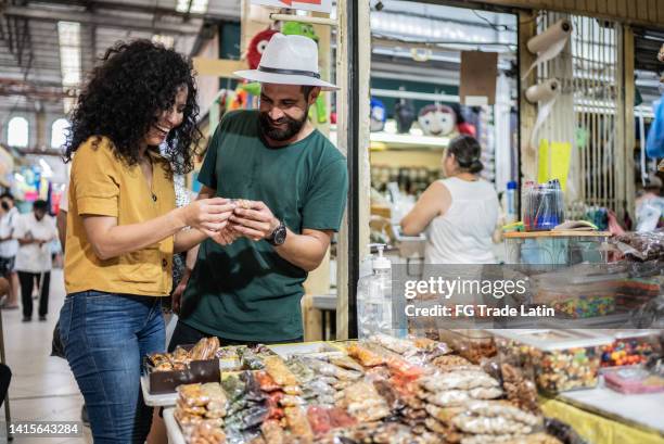 young couple buying nuts in a store at the local market - real people shopping stock pictures, royalty-free photos & images