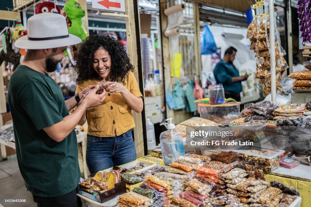 Young couple buying nuts in a store at the local market