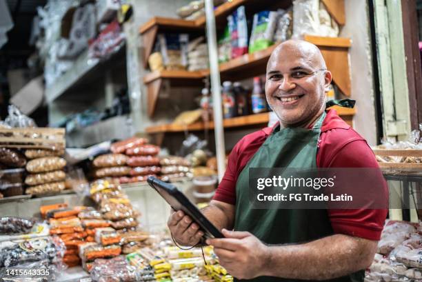 portrait of mature man small business owner using digital tablet - mexico market stock pictures, royalty-free photos & images