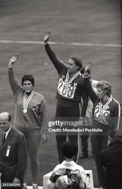 Soviet athletes Tamara Press and Galina Zybina greeting with a wave from the podium alongside East German athlete Renate Garisch-Culmberger during...