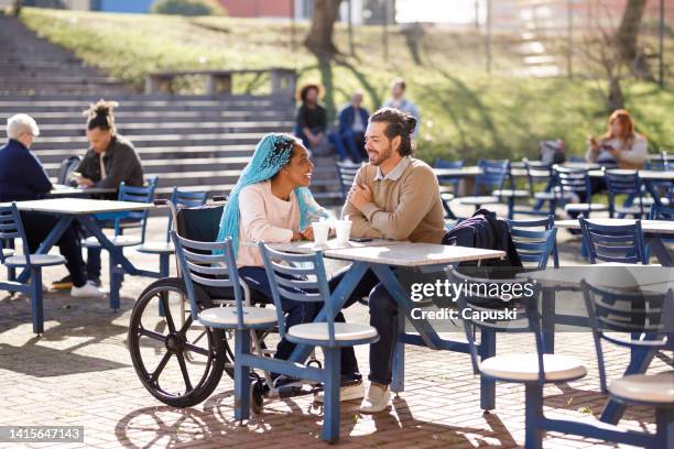 couple chatting while having a break on campus - mannenknot stockfoto's en -beelden