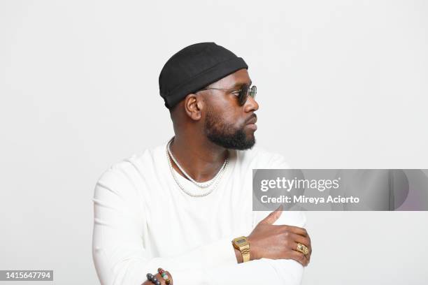 portrait of a fashionable african american millennial male with a beard, standing in front of a white background wearing a white long sleeved shirt, a black beanie hat, jewelry and sunglasses. - 長袖 ストックフォトと画像