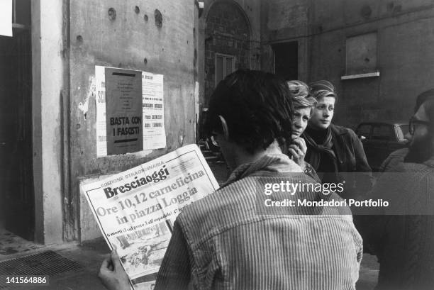 Young Italian man reading the extra edition of the newspaper 'Bresciaoggi' after the Piazza della Loggia bombing. Brescia, 28th May 1974