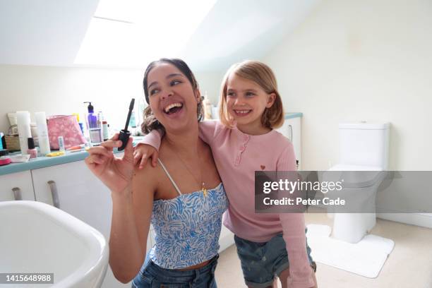 mother applying make-up to daughter - crop top stock pictures, royalty-free photos & images