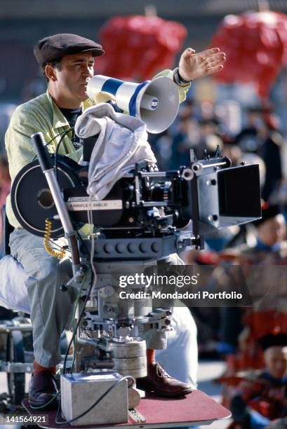 The Italian film director Bernardo Bertolucci directing the shooting of the film 'The Last Emperor' with a loudhailer. 1987