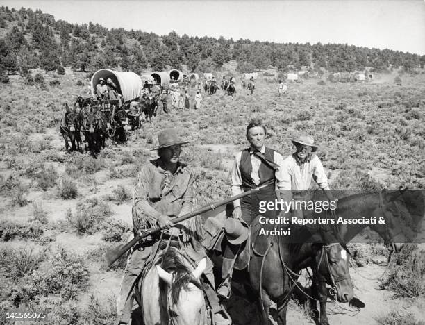 Wagon train of settlers in the western movie 'The Way West' is led through the American open grassland by three men on horseback, the US actors...