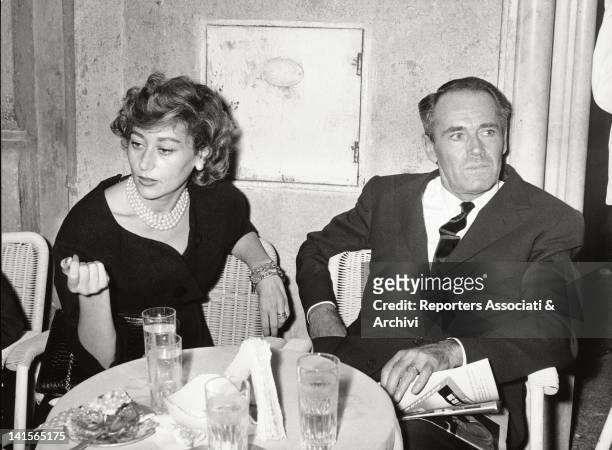 The US actor Henry Fonda is sat down at a table in a bar of Rome with his fourth wife, the baroness Afdera Franchetti. Rome, October 1958.