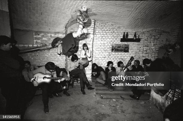 Italian beatniks having a rest and playing at Mondo Beat club in Milan. Milan, 1960s