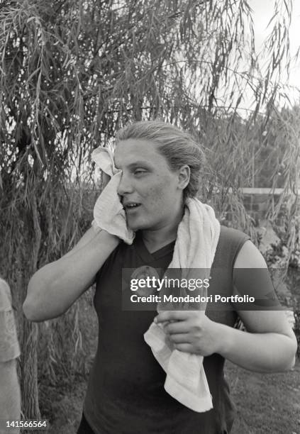 Soviet shot putter Tamara Press drying her face at the end of her training during the Rome Olympic Games. Rome, 1960