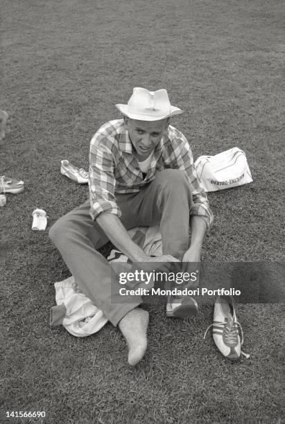 German athlete Armin Hary wearing a pair of Adidas shoes at prize-giving of 100-metre sprint race. Puma was his sponsor during the race. Rome, 1960