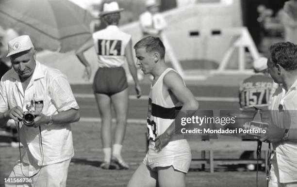 Two photographers surrounding the German athlete Armin Hary. Rome, 1960