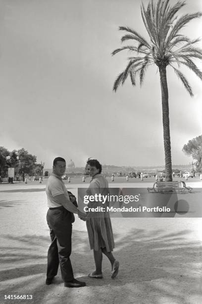 American athlete Harold Connolly walking hand in hand on the Pincian Hill with the Czechoslovakian athlete Olga Fitokova, his wife. Rome, 1960