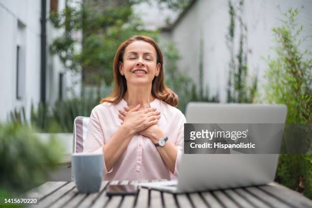 happy business woman getting good news while working on her laptop - breathing exercise stock pictures, royalty-free photos & images