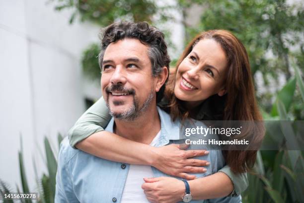 portrait of a loving adult couple hugging and smiling - roof garden stock pictures, royalty-free photos & images
