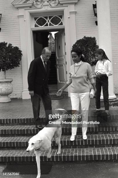The Italian industrialist Bruno Pagliai looking at a dog with his wife the American actress Merle Oberon and the foster daughter Francesca in their...