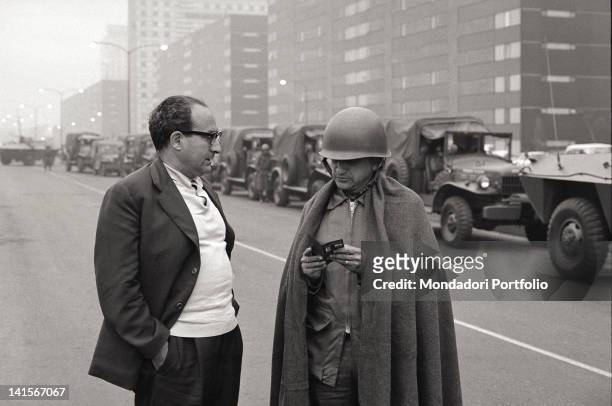 Mexican soldier checking an identification of a man in a street of Mexico City full of jeeps in a line to fight the student movement. Mexico City,...