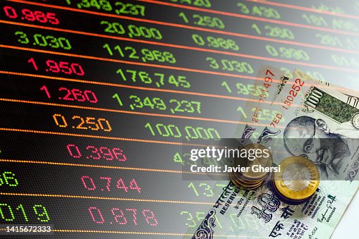 Indian Rupees cash banknotes and coins and stock market indicators Indian Rupees cash banknotes and coins and stock market indicators