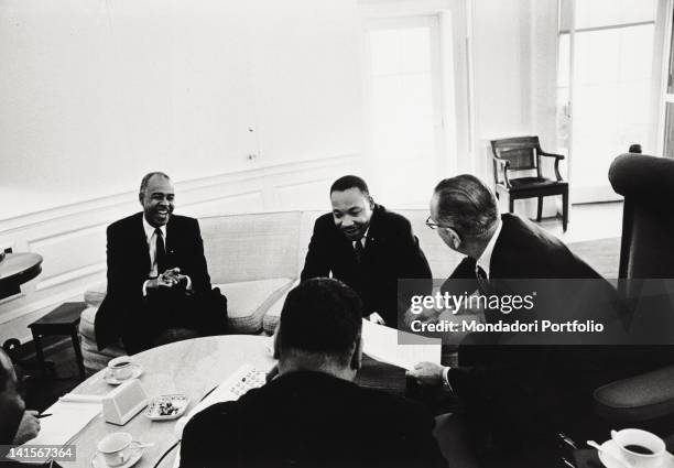 The President of the United States Lyndon Johnson at the White House smiling with Reverend Martin Luther King and Roy Wilkins. Washington, 1960s