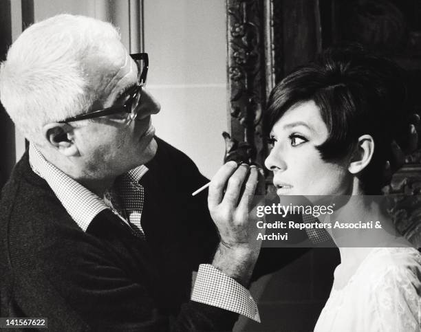 The British actress Audrey Hepburn being painted on the set of the film 'How To Steal a Million' by William Wyler. 1965