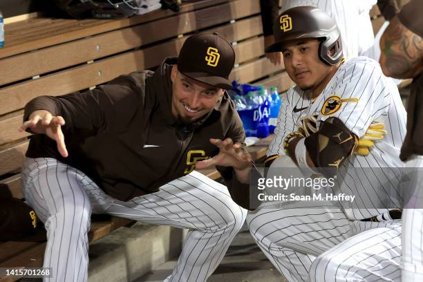Blake Snell congratulates Manny Machado of the San Diego Padres as they pose for a photo in the dugout after his solo homerun during the fourth...