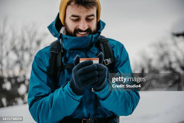 warm tea while hiking on the mountain - ski jacket stock pictures, royalty-free photos & images